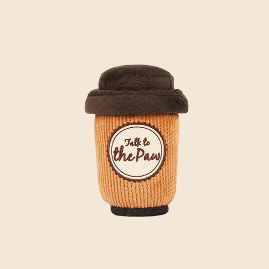 Dog toy resembling a coffee cup with a brown lid on a cream background