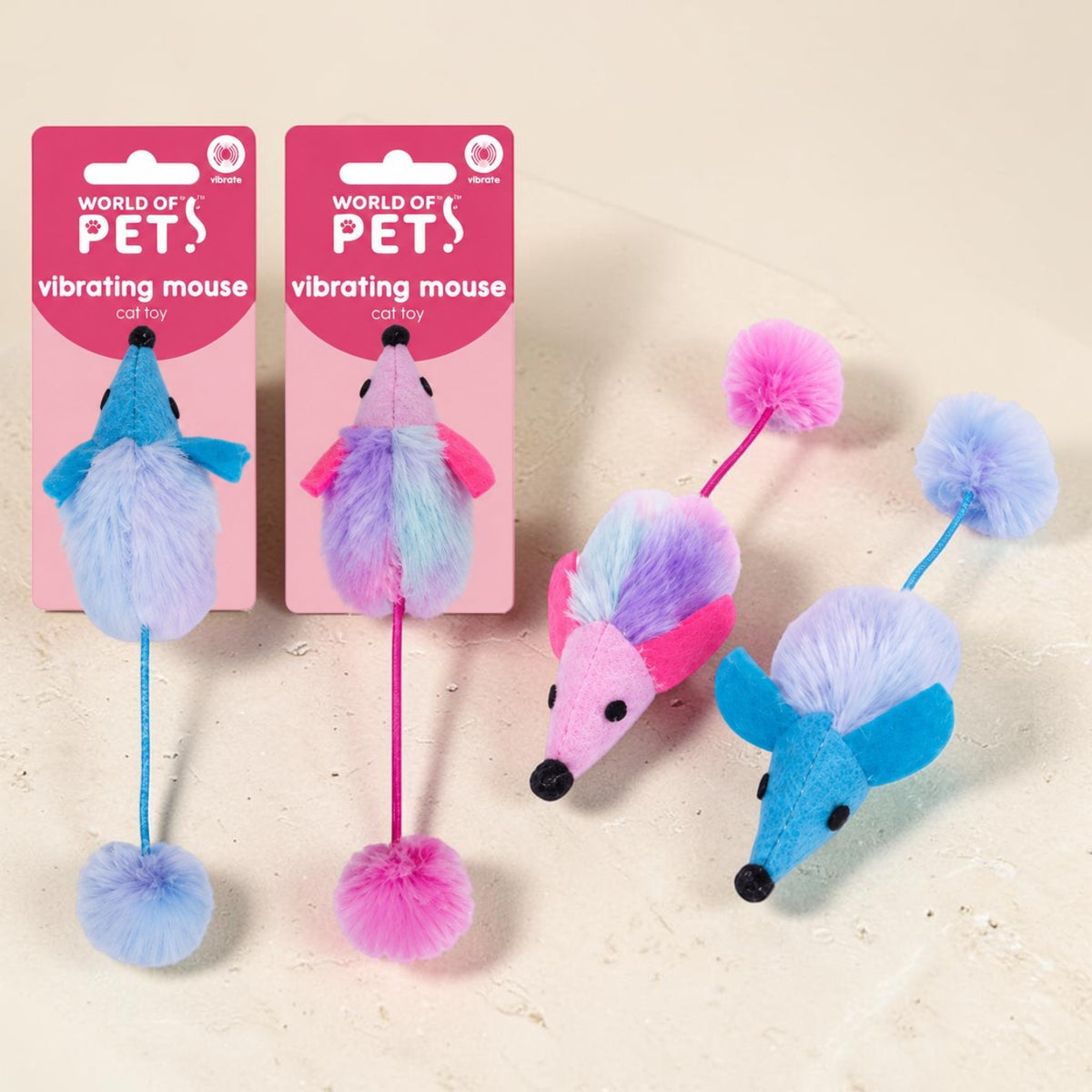 Three colorful vibrating mouse cat toys by World of Pets are displayed on a light beige textured surface, with two shown on their pink retail packaging and one each displayed loose.