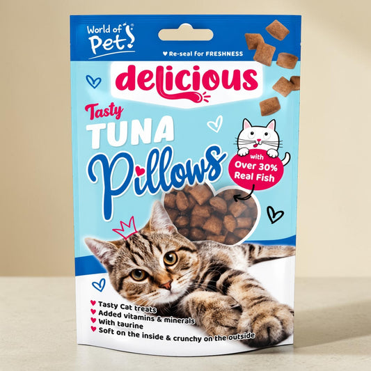 A stand-up pouch of World of Pet Delicious Tuna Pillows cat treats, featuring a tabby cat illustration and a clear window showing brown tuna-shaped treats inside, set against a neutral beige background.