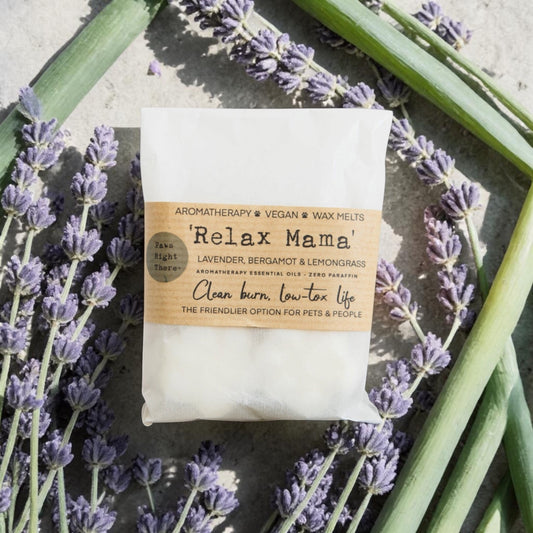 Packaged product labeled 'Relax Mama' surrounded by lavender flowers on a stone surface