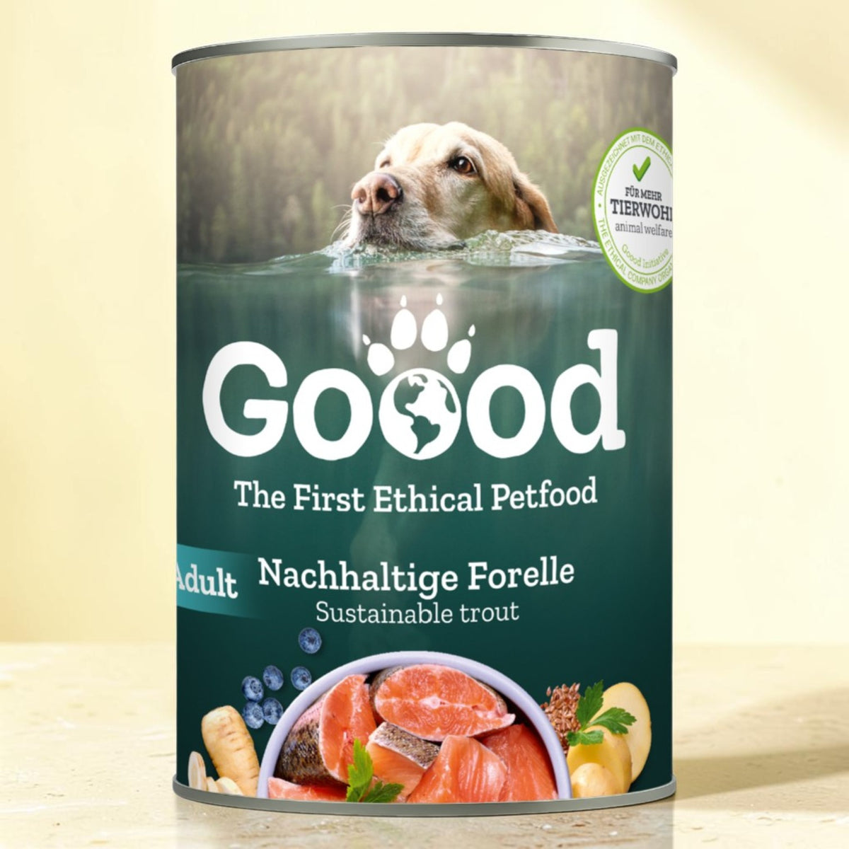 A can of Good brand sustainable trout dog food, featuring a label with a dog swimming in water and fresh salmon, blueberries, and ginger illustrations, set against a warm beige background.