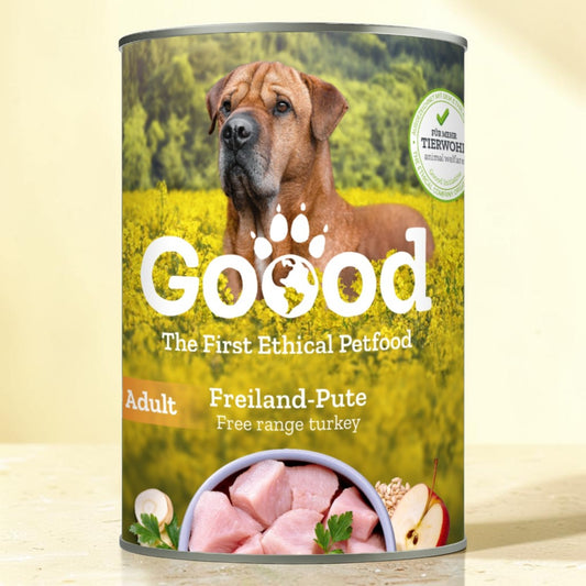 A can of Goood brand dog food, specifically 'Freiland-Pute' adult dry food, featuring a graphic of a brown dog in a green field on the label.
