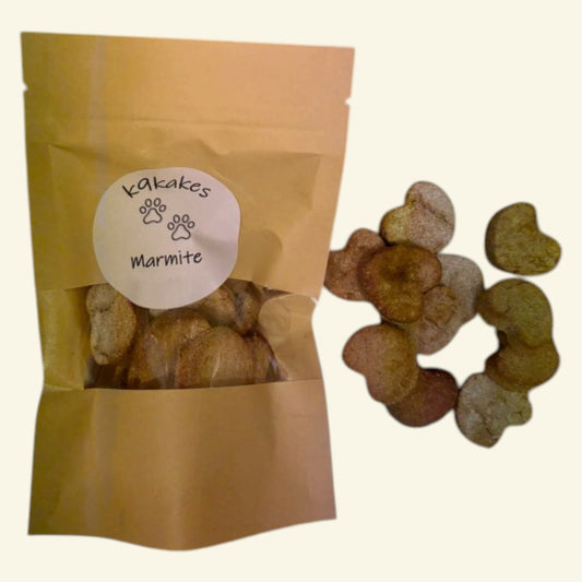 K9Kakes handmade Marmite dog biscuits in a kraft resealable pouch with individual bone-shaped treats displayed alongside.