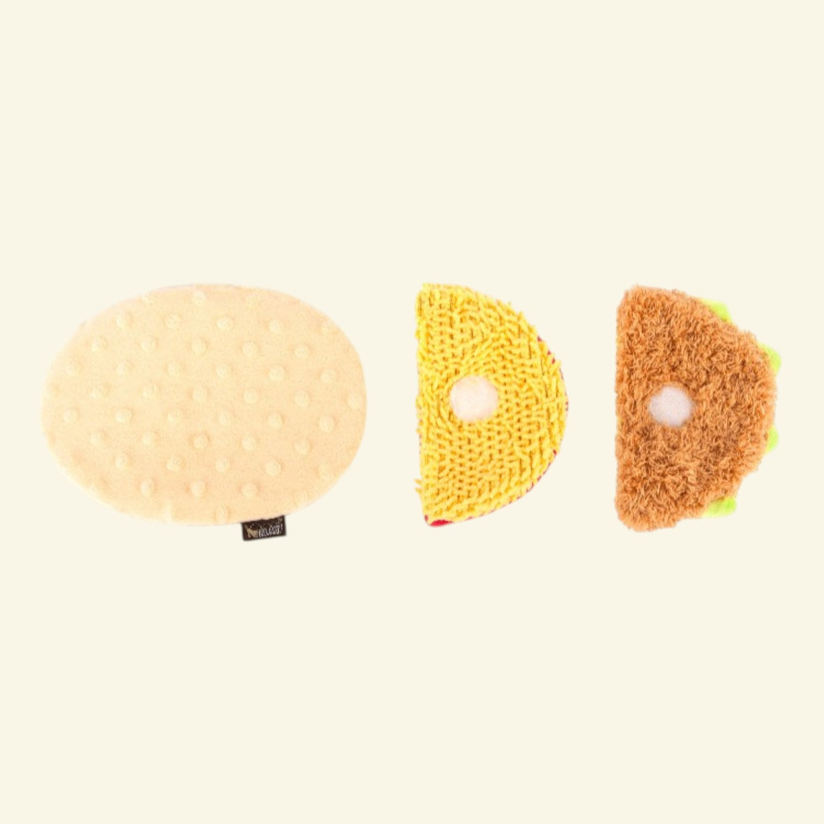 Three plush dog toys shaped like a sandwich, cheese slice, and oval bun on a plain cream background.
