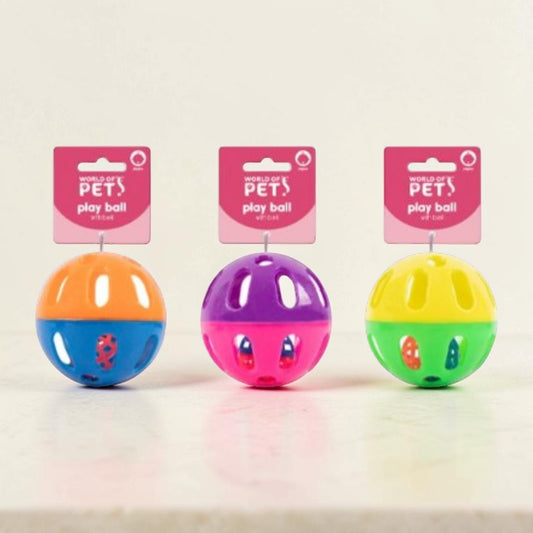 Three colorful plastic pet toy balls on pink retail hangers against a plain light background. The balls are orange/blue, purple/pink, and yellow/green, each with small cutout details.