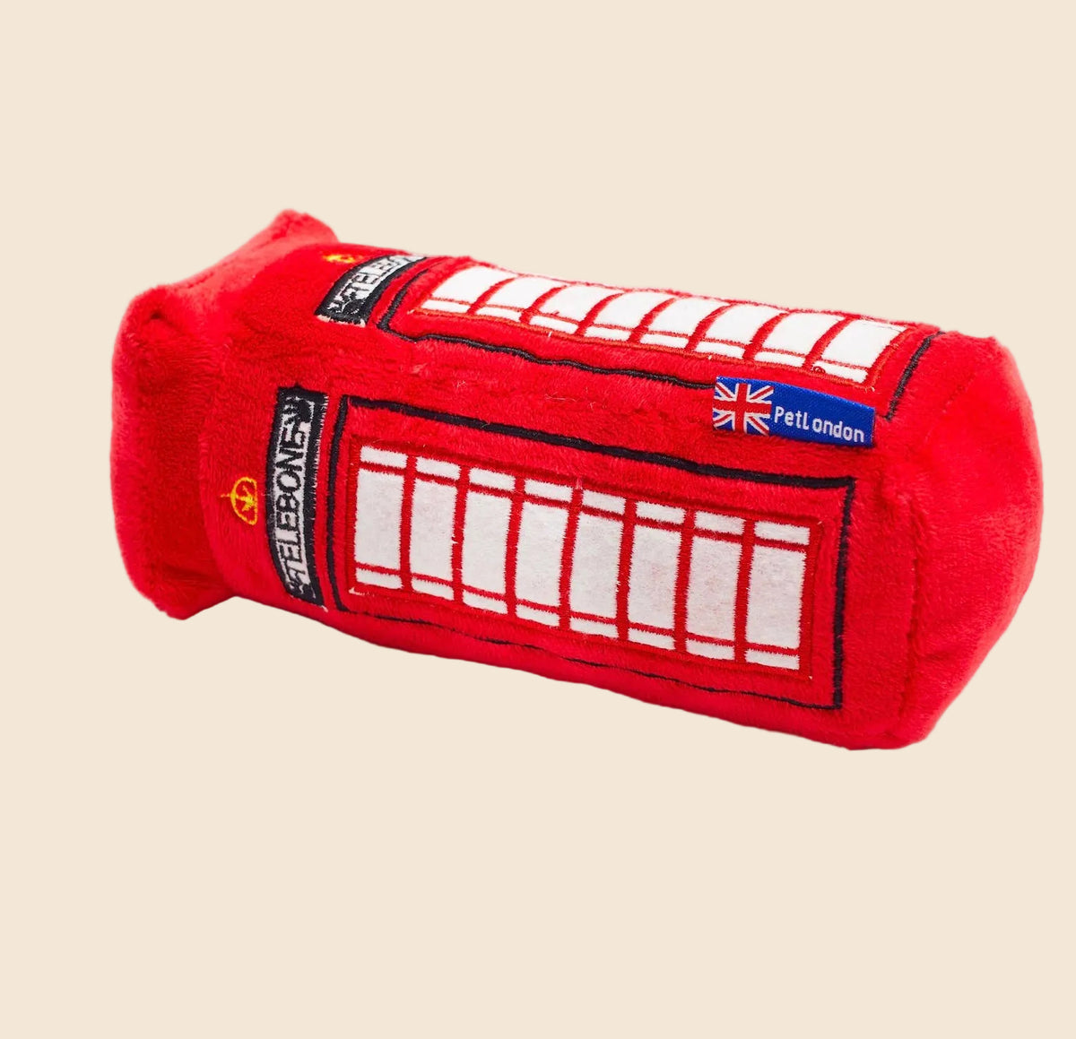 Red plush toy shaped like a London telephone booth on a cream background